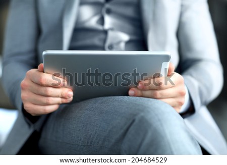 Young adult working on a digital tablet. Businessman holding digital tablet