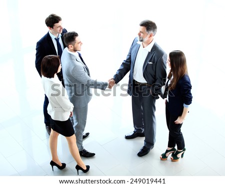 Top view of  business people shaking hands, finishing up a meeting - Welcome to business