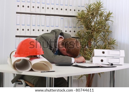 a man sleeping behind his office desk