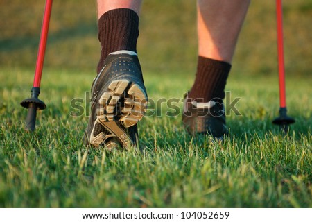Nordic walking in summer. Closeup of man\'s legs with nordic walking poles