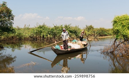 SIEM REAP, CAMBODIA - DECEMBER 09: Locals paddle a boat down one of many channels in the wetland, in Siem Reap, Cambodia on December 09, 2009