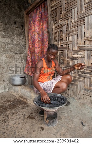 MONROVIA, LIBERIA - FEBRUARY 23: An African woman prepares food outside her home, in Monrovia, Liberia on February 23, 2012