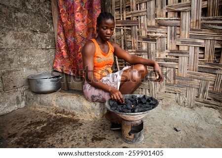 MONROVIA, LIBERIA - FEBRUARY 23: An African woman prepares food outside her home, in Monrovia, Liberia on February 23, 2012