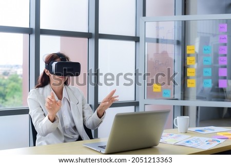 Caucasian business woman are Video conference with Visual reality or VR headset glasses technology in modern office. Metaverse and virtual technology concept.