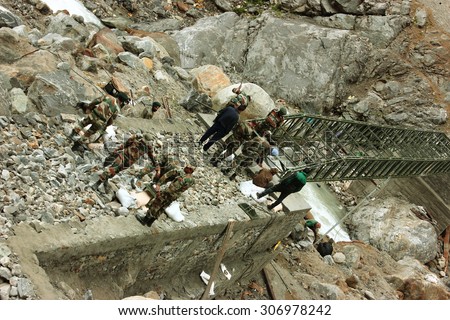 KEDARNATH, INDIA - MAY 31, 2015: Indian army constructing a foot bridge on Kedarnath trek route in Himalaya region in Kedarnath, Uttarakhand, India.  This region was heavily affected in 2013 floods.