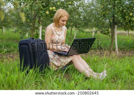 The beautiful blonde with a laptop on the nature