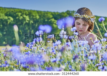 View of a young girl with a wreath of white daisies in her hair