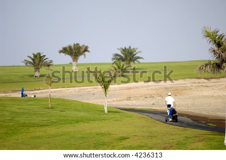 Golfer walking at path to next hole