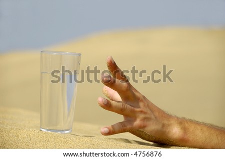 Hand is reaching for a fresh glass of cold water in desert.