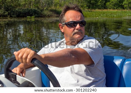 mature men driving motor boat in a river