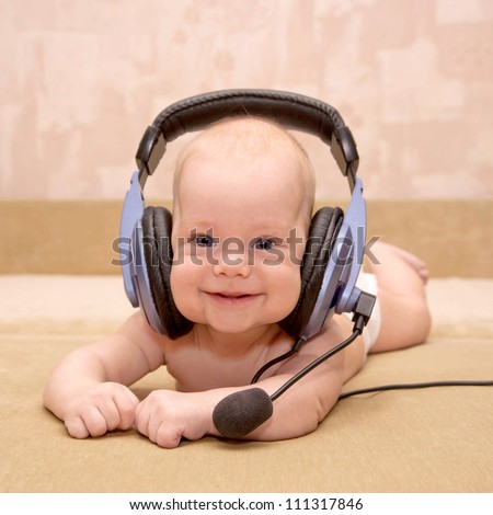 Nice newborn baby with blue eyes smiling wearing a headset. \