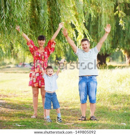 Happy family concept. Father, mother and son hands up and shouting outdoors . Summer holiday.