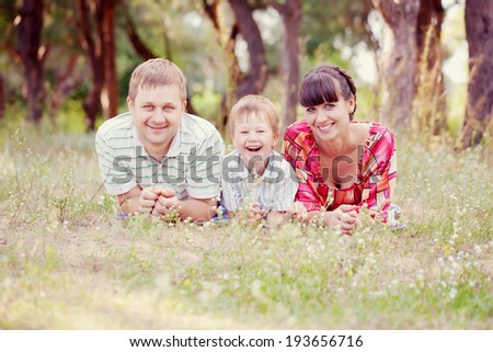 Father, mother and son in the park. Summer holiday. Happy family outdoors. Retro style.
