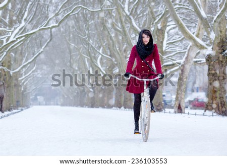 beautiful girl on bike at snow wonderland,  winter biking