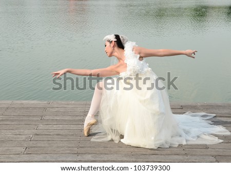 Beautiful woman in white gown of the bride dance like ballet dancer