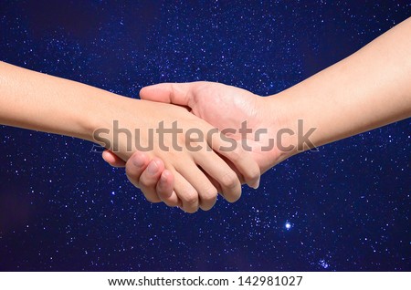 Partner hand between a man and a woman on Night sky with stars background, Teamwork