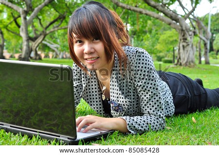 Smiling woman with laptop in nature