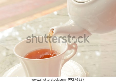tea pouring into glass tea cup