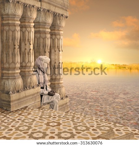 Old indian man praying in the sunset.