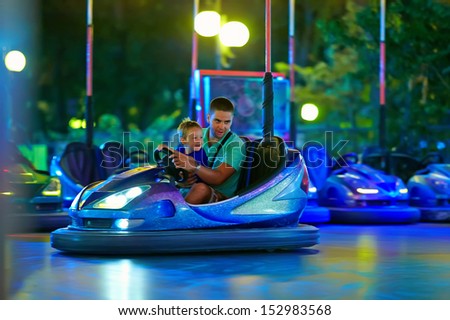 father and son having fun, driving electric toy car