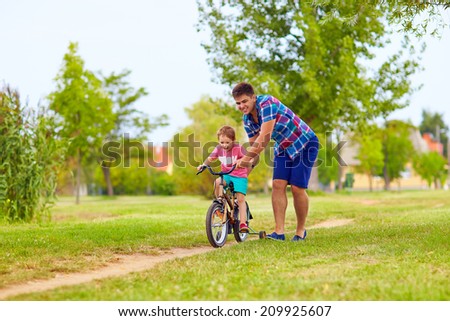 father teaches son to ride the bicycle