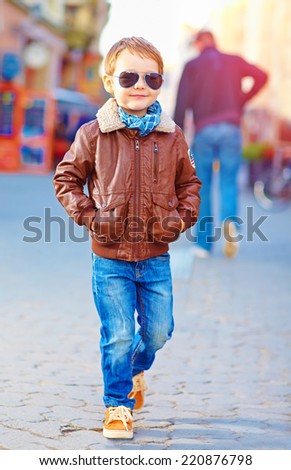 stylish happy boy walking the crowded street