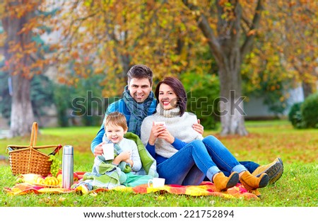 happy family drinking warm tea on autumn picnic