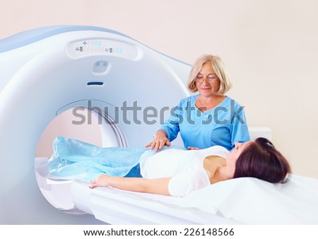 mid adult medical staff preparing patient to tomography