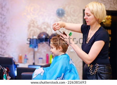 little client, boy having haircut at hair salon