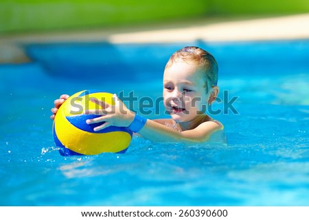 cute kid playing water sport games in pool