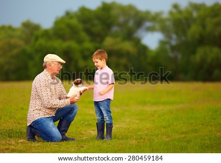 grandpa presenting little puppy to excited grandson