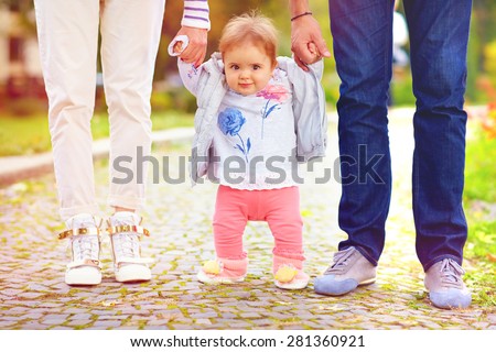 cute little baby girl on walk with parent, first steps