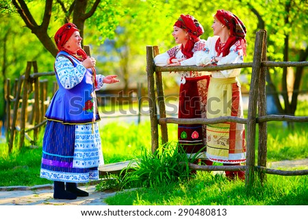 happy ukrainian women, dressed in traditional costumes, talking on the street