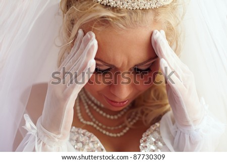 close-up portrait of a beautiful bride frowned because of troubles and pain. white background