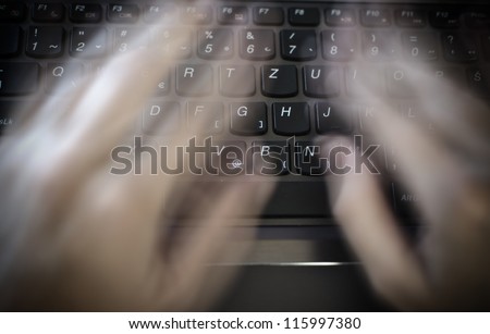 Person typing incredibly fast on a keyboard, fingers are blurred to show speed