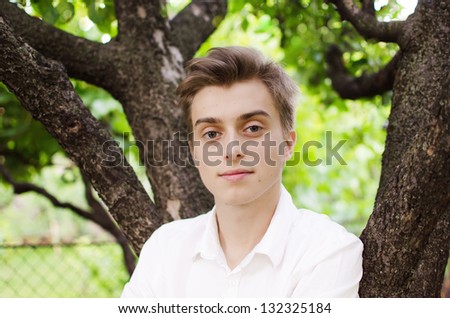 Young handsome man outdoors in fall clothing with spring natural surroundings