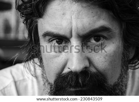 Portrait of a serious handsome man with a beard, black and white image