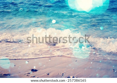 background of blurred beach and sea waves with bokeh lights, sandy beach with turquoise water, bright white sun lights bokeh, travel and summer holidays concept, vintage and retro effect