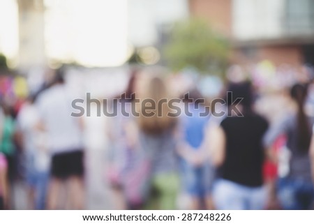 Crowd of People Walking On the Street in Bokeh, unrecognizable group of men and women as blur urban background.