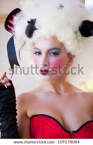 Beautiful Woman with heavy party makeup wearing a corset and gloves