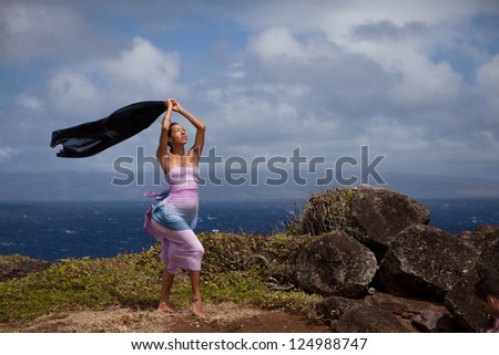 Pregnant woman Celebration of a new beginning on a bluff above the ocean in Hawaii