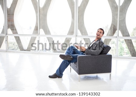 Attractive business man in his 20s working on a think pad in a wide open space