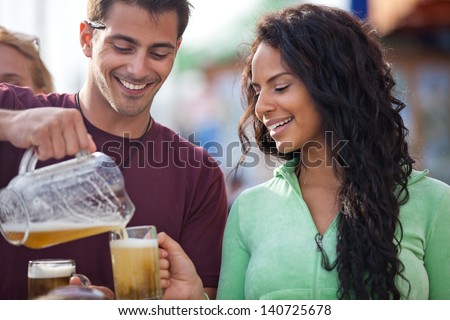 Attractive Man pouring a beer at an outside cafe on the Beach in Venice California