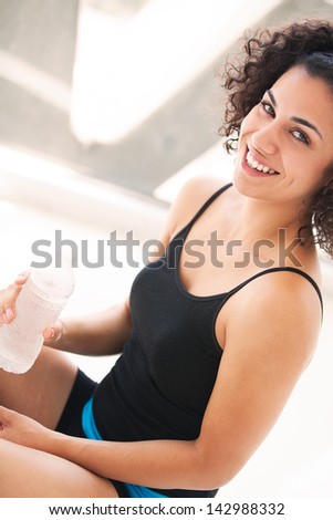 Beautiful woman drinking iced cold water after her work out