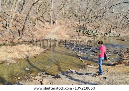 GREAT FALLS,MD-MARCH 30: Woman with a Dog at Great Falls on March 30, 2013 in Maryland USA.Famous Chesapeake and Ohio Canal, C&O Canal, about 184.5 miles,people visit ,and do many outdoors activities.