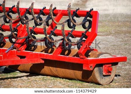 Red farm tool used to remove and flatten the farmland