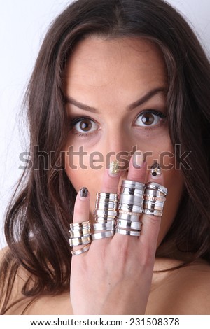 beautiful young brunette with a lot of gold and silver wedding rings on her fingers in the studio - portrait of a female model
