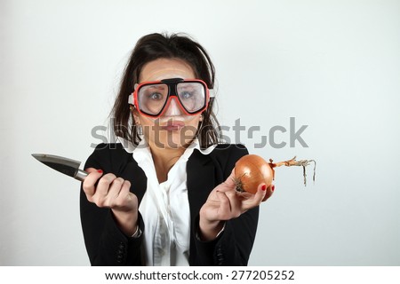 beautiful young brunette cook onion peels with a diving mask on her face - funny facial expressions