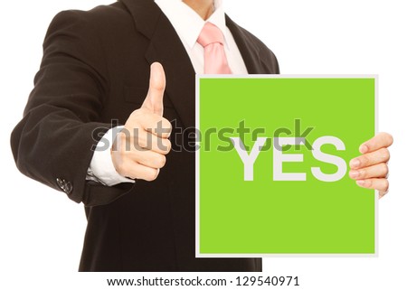 A businessman doing a thumbs up sign and holding signboard indicating Yes