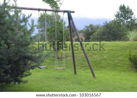 double child\'s wood swing in the garden.